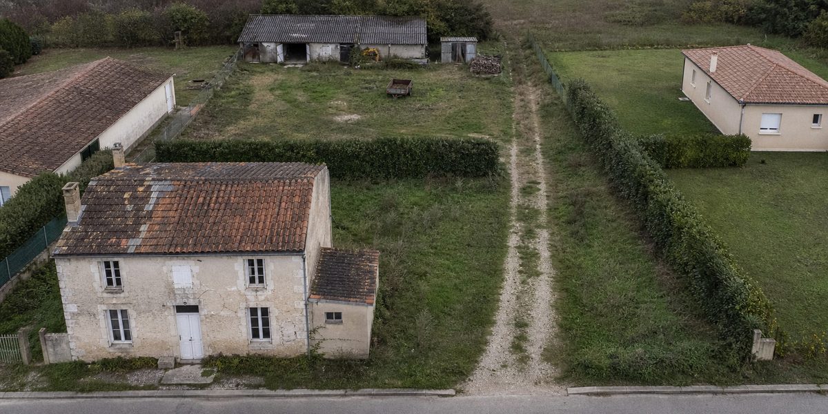 Maison en pierre en bordure de rue, grange et terrain libre en fond de parcelle